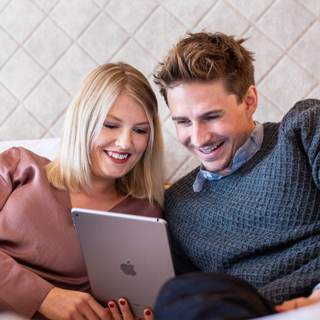 Ein Pärchen nutzt die Digitale Gästemappe von Gastfreund auf einem Tablet
